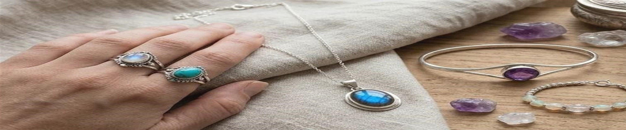 Gemstone jewelry arranged on a silver and stone worktable